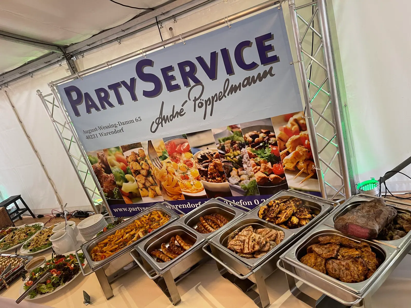 Warmes Buffet in Chafing Dishes vor dem Banner von Partyservice André Pöppelmann