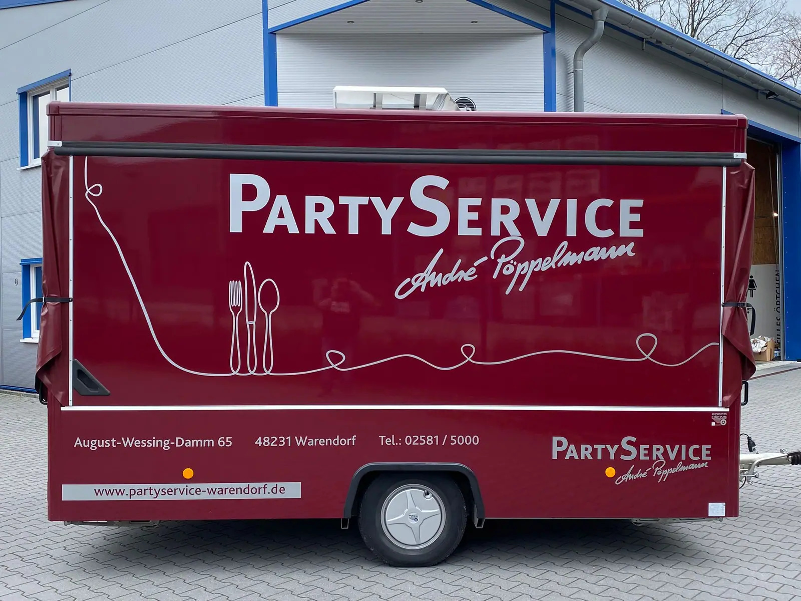 Roter Cateringanhänger mit Partyservice-Pöppelmann-Beschriftung